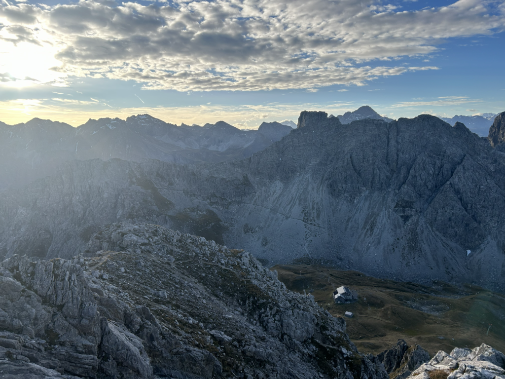 Panorama mit Blick auf die Fiderepasshütte im Allgäu, Hütte am Fuße schroffer Gipfel, sonnige Bergkulisse und weite Talblicke – fotografiert von Bergkompass Bergwanderführer Pascal Schirmer