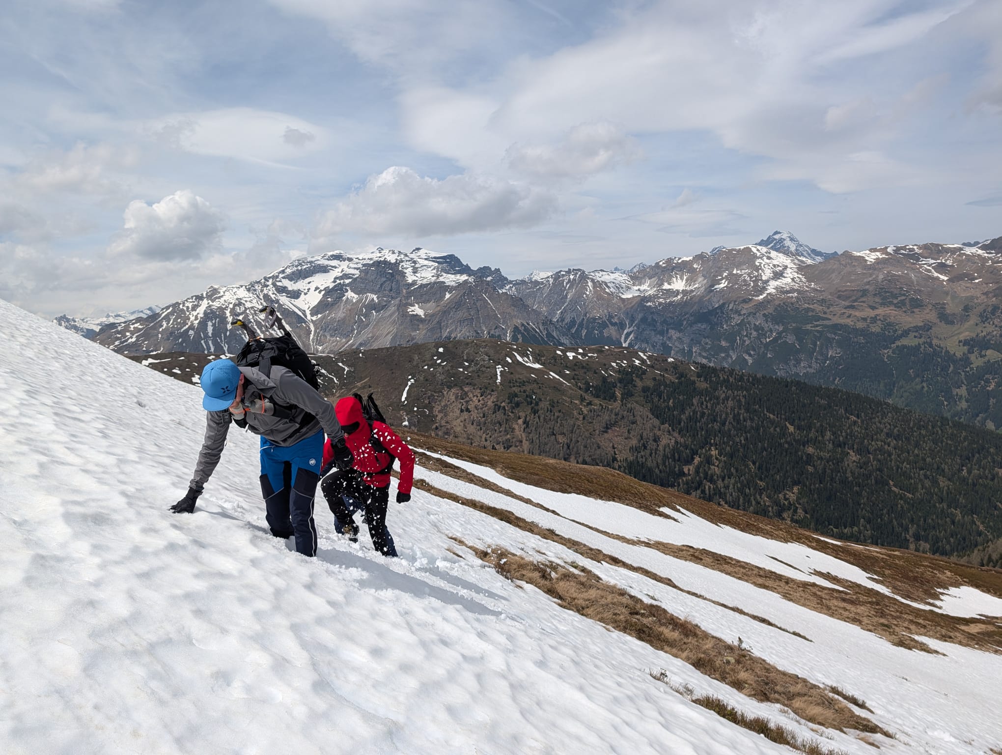 Bergwanderführer Pascal von Bergkompass unterstützt Gäste beim Aufstieg über ein Schneefeld