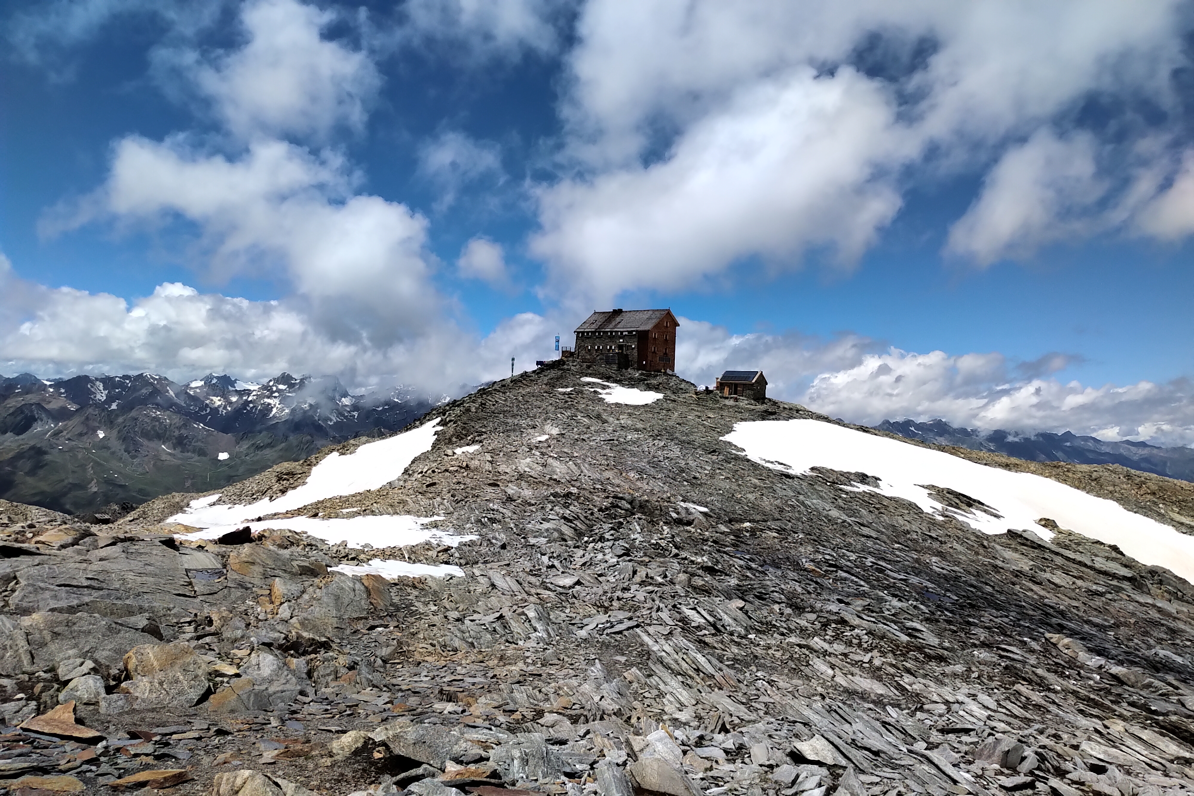 Hochstubaihütte auf der Wildkarspitze, eingebettet in hochalpines Fels- und Schneegelände mit weitem Blick auf die umliegenden Ötztaler Gipfel – fotografiert von Bergkompass Bergwanderführer Pascal Schirmer