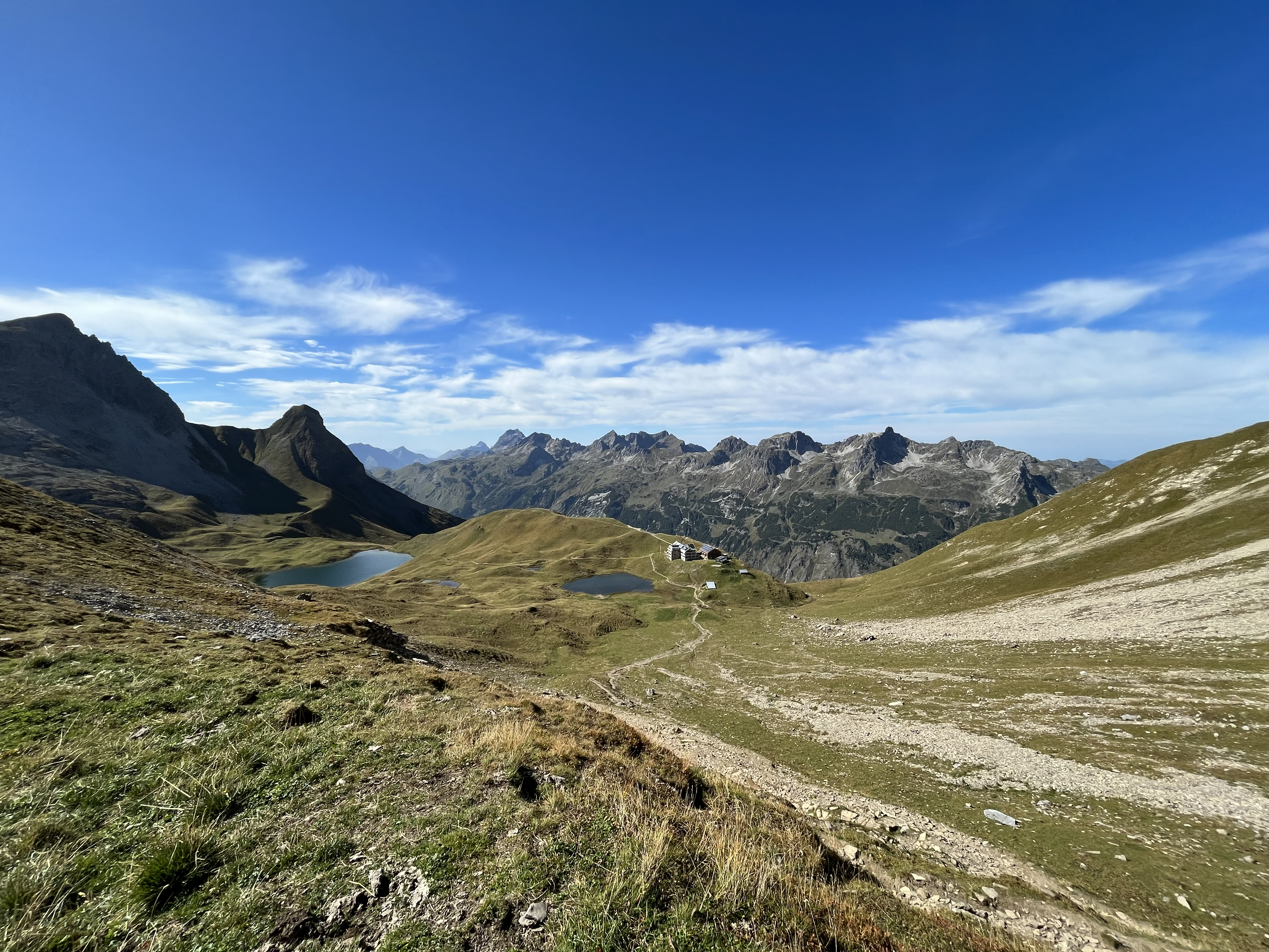 Rappenseehütte am Rappensee, umgeben von markanten Felsflanken und hochalpiner Landschaft – fotografiert von Bergkompass Bergwanderführer Pascal Schirmer